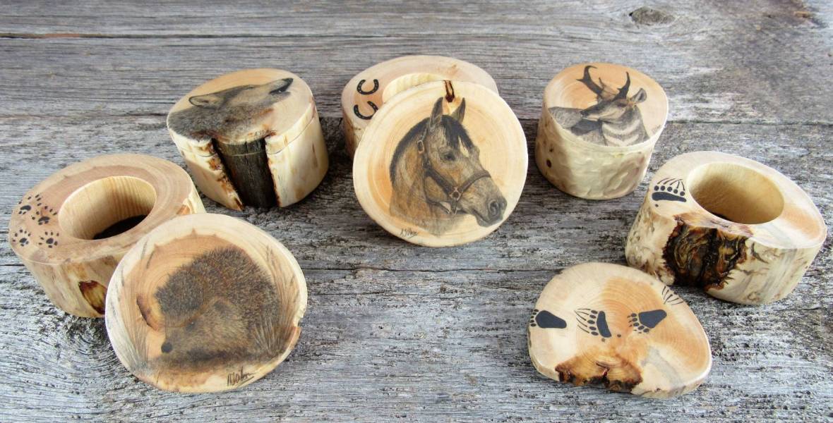 Five wooden ring boxes with animal artwork on each lid.