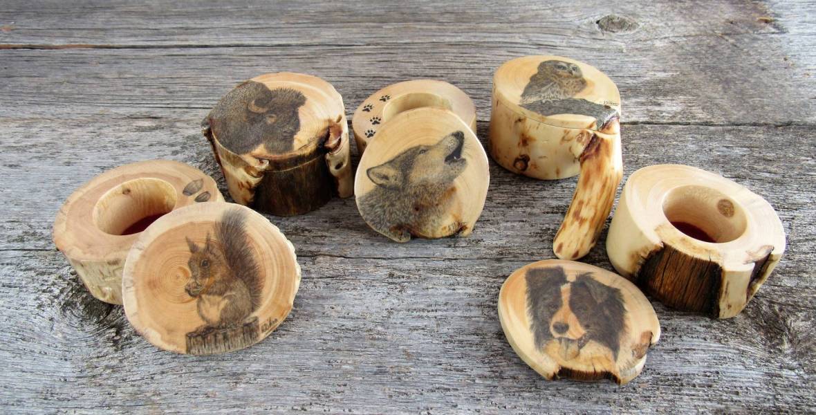 Five wooden ring boxes with animal artwork drawn onto each lid.